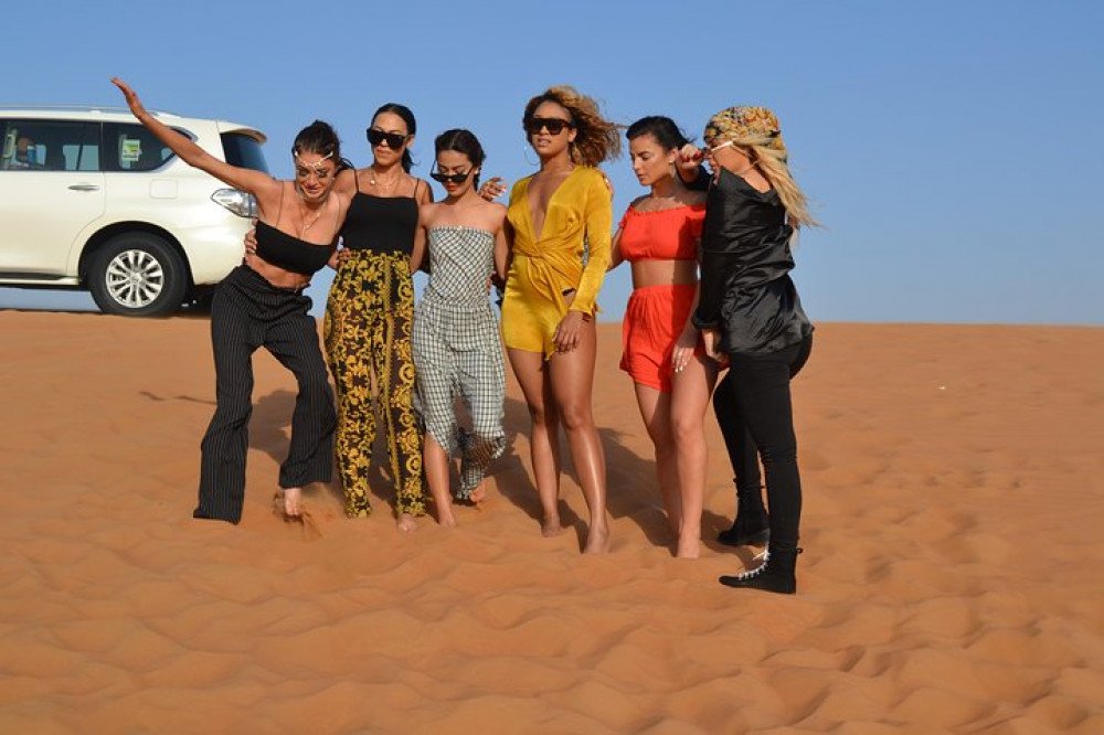 family and couples enjoying dune bashing, camel ride, bbq dinner and live entertainment on the private desert safari in ras al khaimah